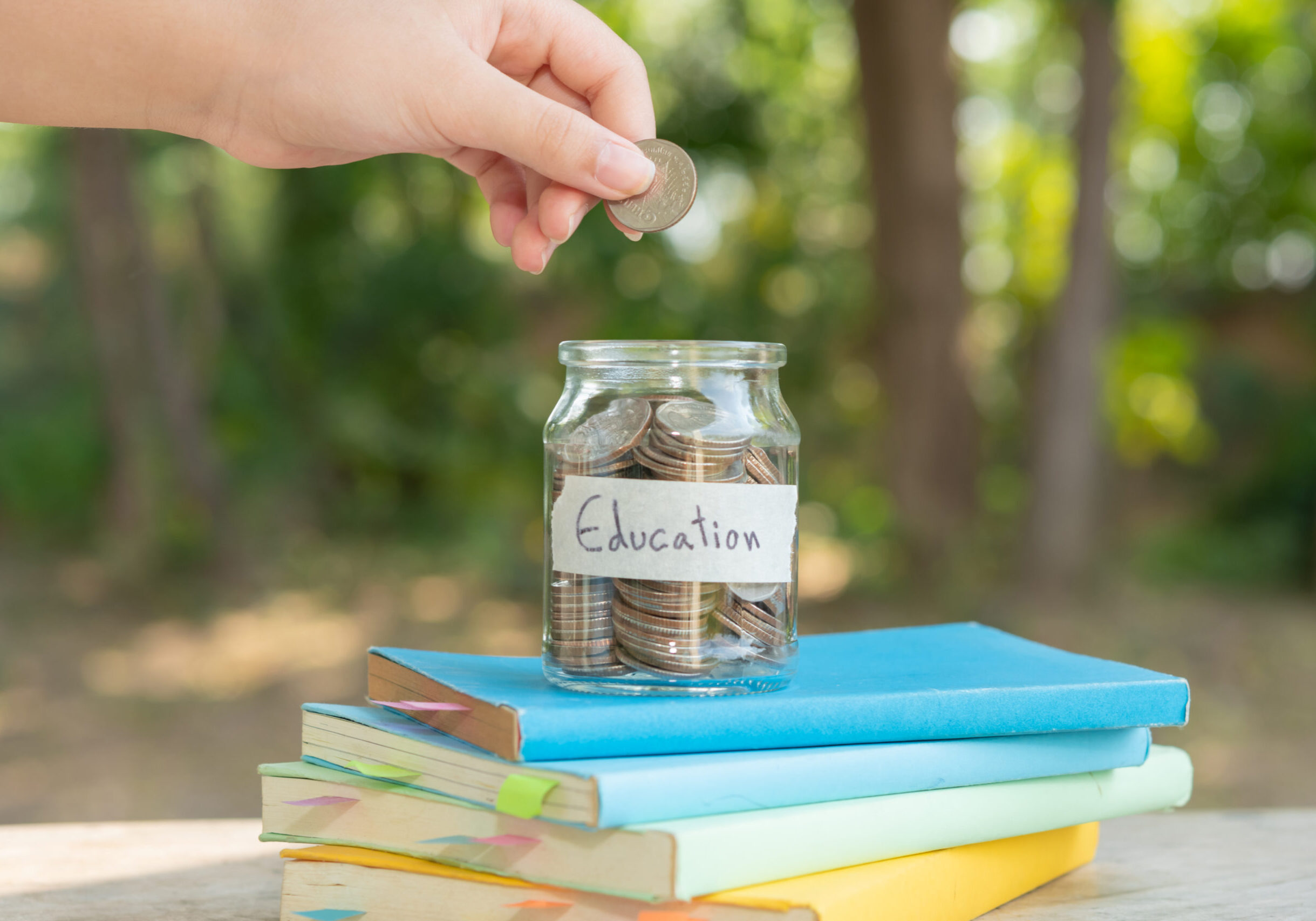 putting money coins saving in glass bottle for concept investmen putting money coins saving in glass bottle for concept investment mutual fund finance and business, placed on the textbook. content money saving for education.